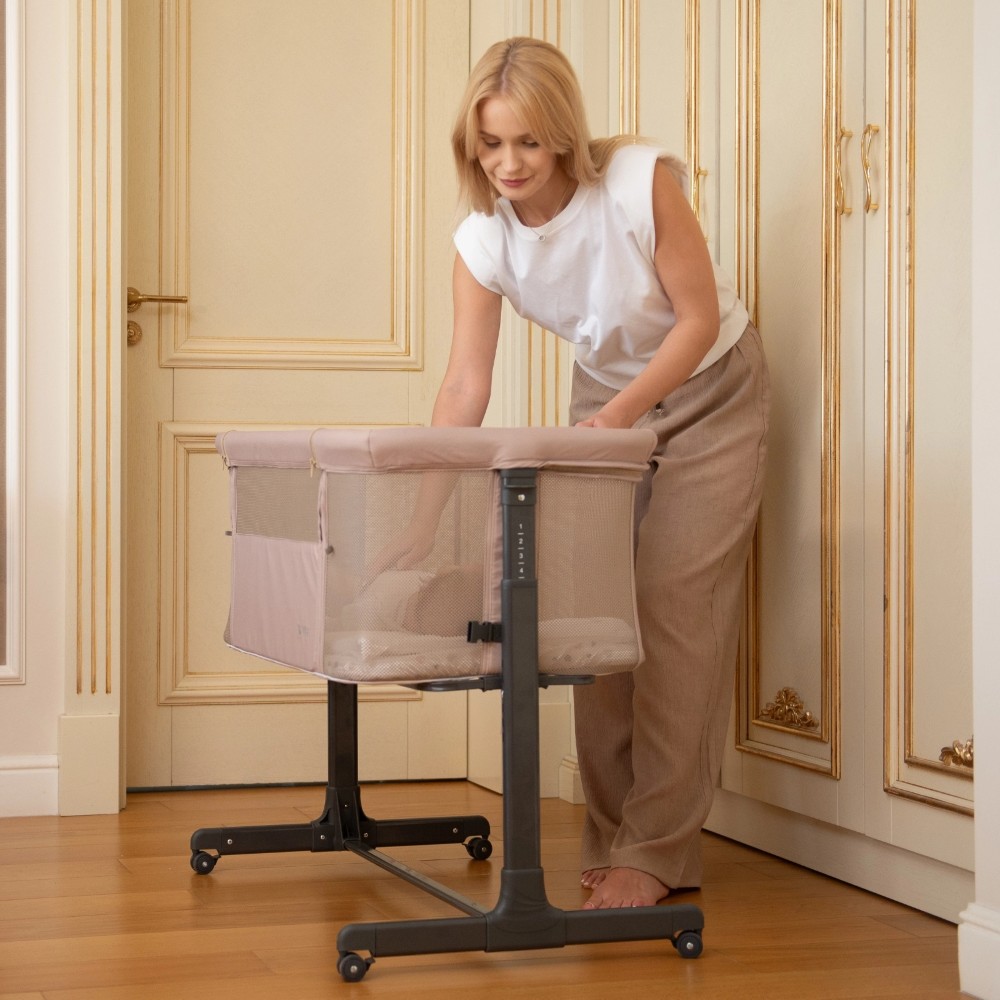 Η φωτογραφία δείχνει Το Bedside Crib NOAH είναι σχεδιασμένο για βρέφη από τη γέννηση έως 6 μηνών, παρέχοντας ένα ασφαλές, άνετο μέρος ακριβώς δίπλα στο κρεβάτι σας βοηθώντας τόσο τους γονείς όσο και το μωρό να επιτύχουν έναν ήσυχο και εύκολο νυχτερινό ύπνο.