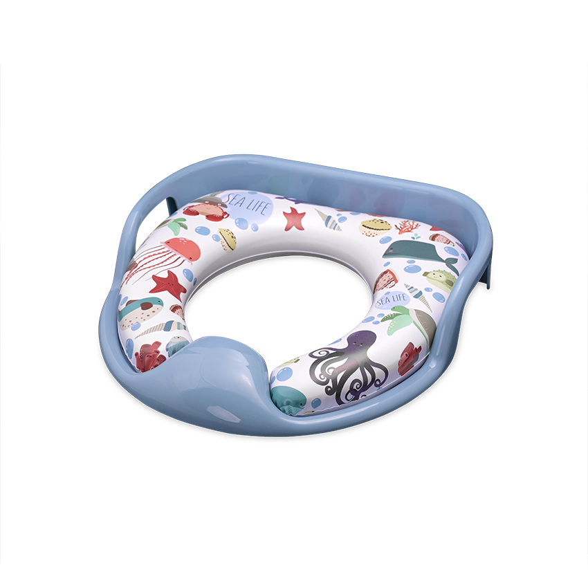 Η φωτογραφία δείχνει Μαλακό εκπαιδευτικό κάθισμα τουαλέτας με χειρολαβεςΤο μαξιλαράκι είναι αποσπώμενο για εύκολο καθάρισμαΔιαθέτει προστατευτικό πλαστικό για την πρόληψη της διαβροχήςΠρακτικές πλευρικές χειρολαβές